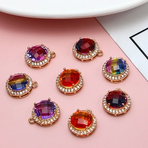 Golden round pendant with gradient crystal and zirconia stones on pink background