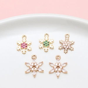 Detalle de colgantes de copo de nieve en cobre con circonitas de colores para joyería