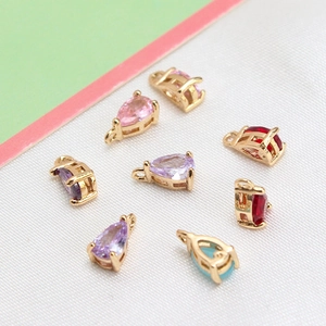 Detailed view of colorful teardrop crystal pendants with golden claw settings for DIY jewelry
