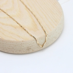 14K gold plated bamboo link chain displayed on a minimalist round wooden base