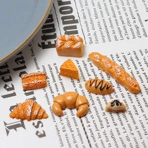 Detailed macro view of miniature resin bakery items like croissants and baguettes