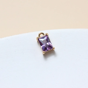Macro shot of 6x10mm purple rectangle crystal pendant with gold-plated brass four-claw setting