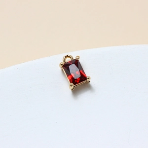 Macro detail of 6x10mm ruby glass rectangle pendant with gold-plated four-prong setting