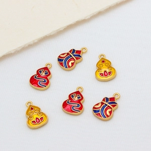 Handcrafted enamel gourd pendants with gold finish and traditional flower patterns