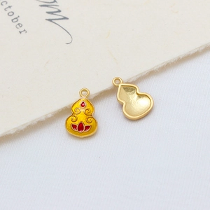 Macro detail of enamel gourd charms with lotus motifs for DIY jewelry making