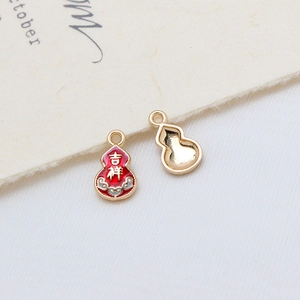 Macro shot of gold-plated Wu Lou pendants with red enamel and auspicious lettering