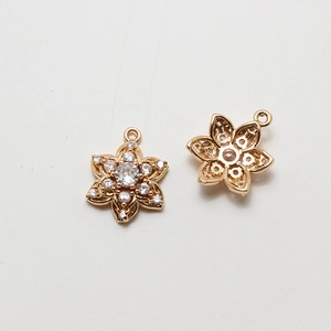 Vue macro d'un pendentif fleur plaqué or avec zircons pour la création de bijoux DIY