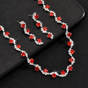 Detail of silver bridal jewelry set featuring vibrant red rhinestones and white crystals