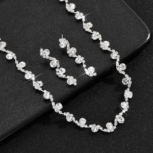 Close-up of wavy silver-plated bridal necklace and earring set with sparkling rhinestones