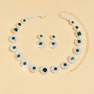 Detailopname van luxe sieradenset met smaragdgroene ketting en bijpassende oorbellen