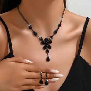 Dettaglio elegante set gioielli con fiori neri, collana e orecchini a goccia in cristallo