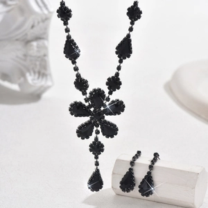 Macro di collana con fiori in cristallo nero e orecchini abbinati su base di pietra