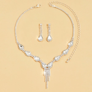 Detailed view of teardrop crystal necklace and earrings set with rhinestone tassels