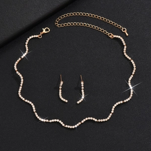 Gros plan sur l'ensemble collier et boucles d'oreilles de mariée avec cristaux et dorure