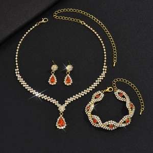 Details des goldenen Schmucksets mit roten birnenförmigen Edelsteinen und Glitzersteinen