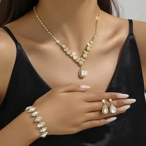 Luxury gold jewelry set featuring teardrop rhinestone necklace, bracelet, and earrings