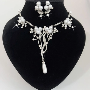Detail van bruidssieraden set met ruitvormige strass hangers en witte hangende parels