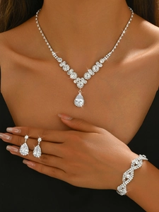 Detailed view of silver bridal jewelry set with pear-cut zircon on a dark model