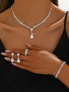 Dettaglio del set di gioielli con collana a goccia e orecchini indossati su modella