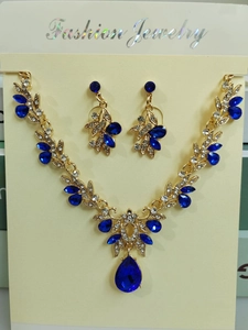 Dettaglio del set da sposa con pendente in cristallo blu scuro e finitura in lega dorata