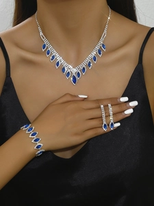 Detail showing sapphire blue marquise cut necklace and earrings set on a female model