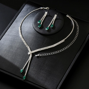 Vue détaillée d'une parure de bijoux de mariage argentée avec pierres vertes et strass
