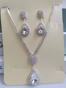 Detailed view of silver water drop necklace and earrings set with pear shaped crystals