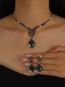 Detailed close-up of a pear-cut black gemstone necklace and matching teardrop earrings
