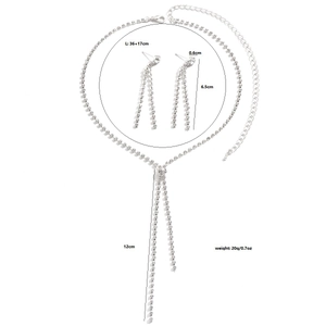 Detailopname van zilveren strass v-halsketting en lange kwastjes oorbellen set