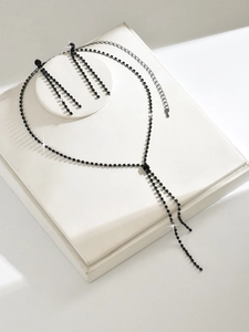 Detail van elegante zwarte kristallen halsketting en bijpassende kwastjes oorbellen set