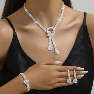 Close-up of sparkling bow tassel jewelry set featuring necklace, bracelet and earrings