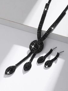 Detailed view of elegant black crystal necklace and drop earrings on white steps