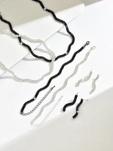 Détail macro de parure de bijoux ondulée sertie de cristaux noirs et blancs