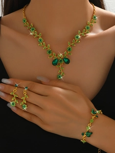 Close-up of elegant emerald green floral jewelry set with necklace earrings and bracelet