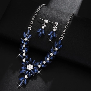 Close-up of floral necklace and earrings set with deep blue marquise-cut crystals