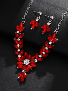 Close-up of red leaf-shaped stone necklace and matching drop earrings bridal set
