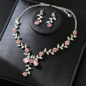 Detailed macro view of pink floral jewelry set with crystal teardrop necklace and earrings
