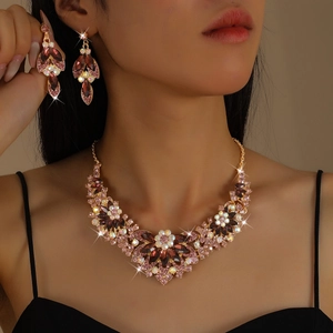 Luxury gold jewelry set with purple gemstones and crystals featuring floral necklace and earrings