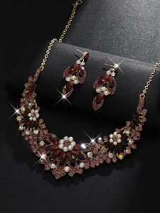 Macro detail of luxury gold jewelry set featuring deep red gems and sparkling crystals