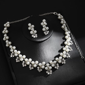 Elegante set di gioielli da sposa con perle bianche e strass scintillanti su nero