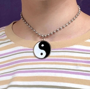 Detail van een zilveren ball ketting met een zwart en witte Tai Chi Yin Yang hanger