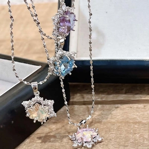 Detailweergave van vier kristallen sneeuwvlokkettingen in paars, blauw, geel en roze