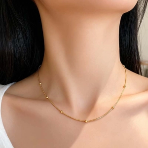Elegant minimalist gold bead snake chain necklace for women shown on neck clavicle