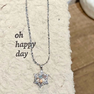 Detailopname van zilveren sneeuwvlok ketting met kristallen hanger op een displaykaart