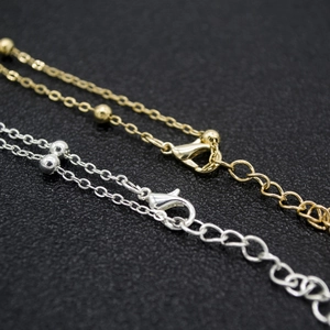 Detail of adjustable gold and silver bikini waist chains with lobster clasps and round beads