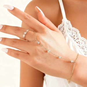 Detail der goldenen Handkette mit Ringen und fünf klaren Kristallen auf einer feinen Kette