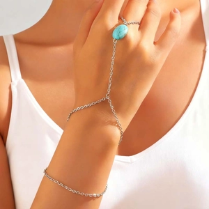 Nahaufnahme einer Boho-Handkette mit ovalem Türkisstein an einer silbernen Gliederkette