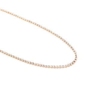 Detailed macro view of gold tennis chain with sparkling crystal rhinestones and claw setting