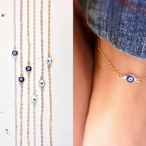 Detailopname van de boze oog enkelbandjes in zilver en goud met blauwe accenten