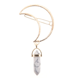 Detail of golden moon hair clip featuring a white turquoise hexagonal pendant and barrette clasp